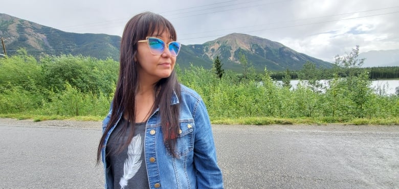 Laurie Strand is pictured in front of a lake and mountain horizon.