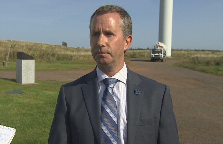 Jason Roberts outside at base of wind turbines.