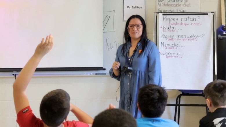 a women stands in class with Mi'kmaq words on the board