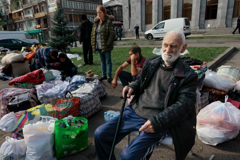 Refugees sit next to their belongings.