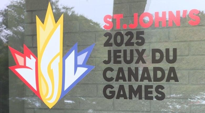 The logo for the 2025 games is seen on a glass window, a slight reflection of light is visible on the glass. 