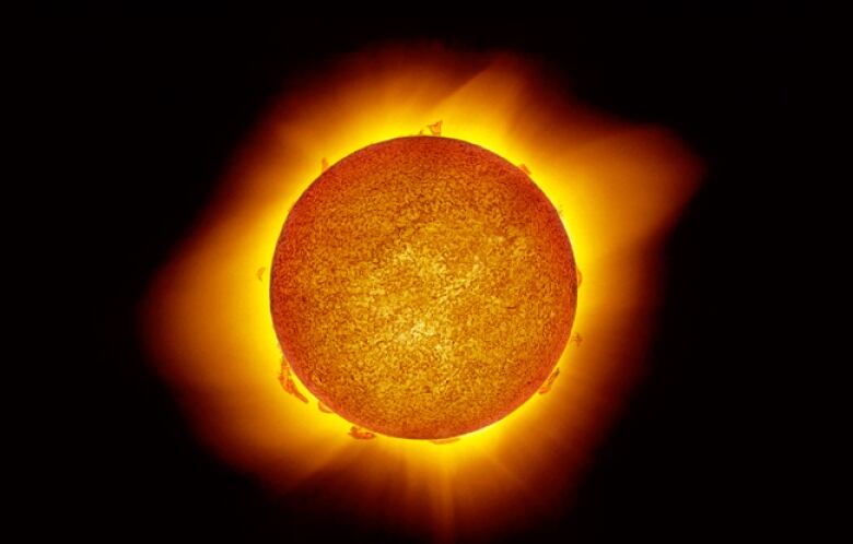 On a pitch black background, a vibran orange ball is centered surrounded by a yellow orange glow. 