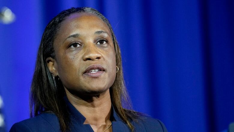 A woman in a blue suit speaks during an event.