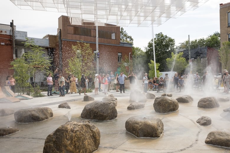 People stand in an urban park outside.