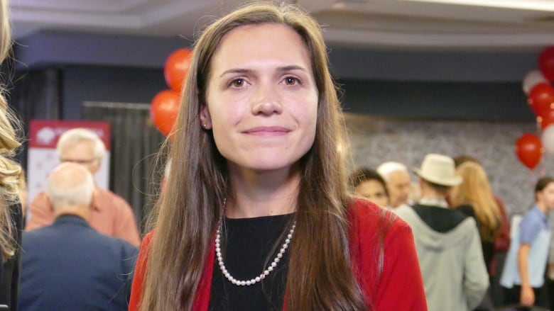 A woman smiles to the camera.