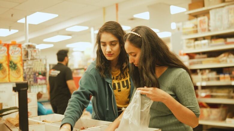 Two shoppers look in a produce bin in a Desi store in Regina.