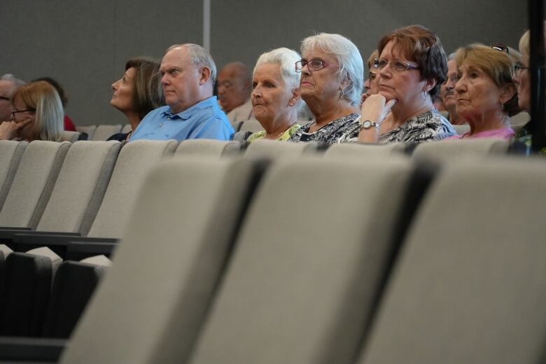 A woman sits between two other women inside of Windsor's city council chambers.