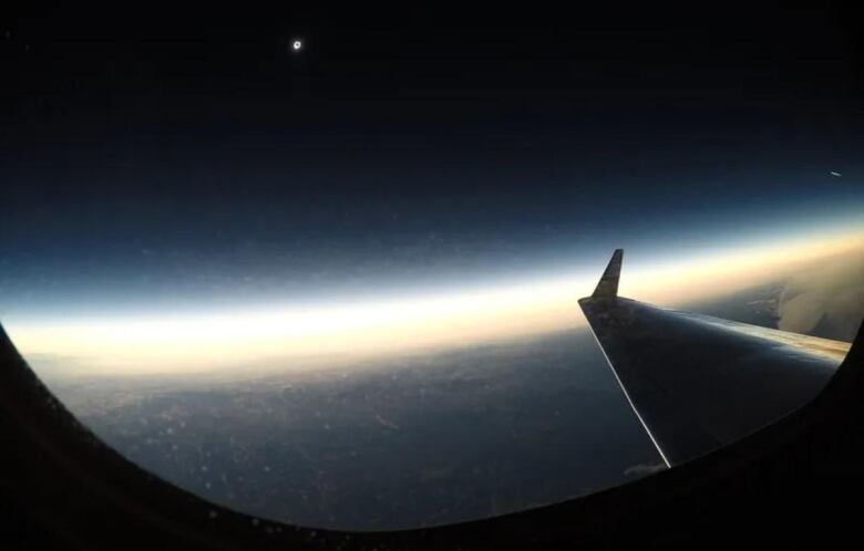 A tiny bright speck in the distance with what looks like a black centre can be seen way off in the distance from the NASA plane that shows how brightly the sun is illuminating the Earth during this eclipse.