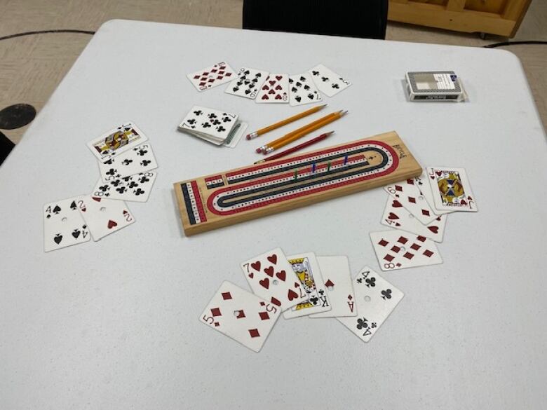 A crib board surrounded by cards. 