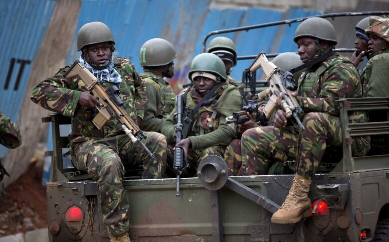 A truckload of soldiers from the Kenya Defense Forces arrives after dawn outside the Westgate Mall in Nairobi, Kenya.