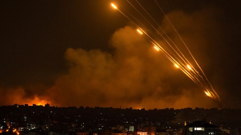 A handful of rockets flare in the night sky.