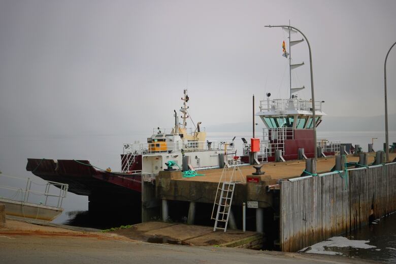 A dead ferry sits at a dock on a foggy day.