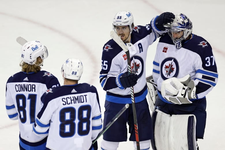 A forward and goaltender congratulate one another after a game.