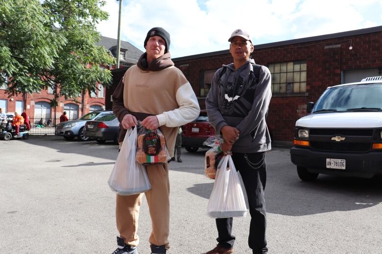 Two men in a parking lot. 