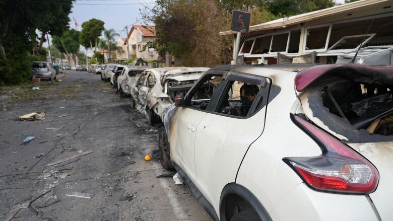 A line of burned cars in  a residential neighbourhood