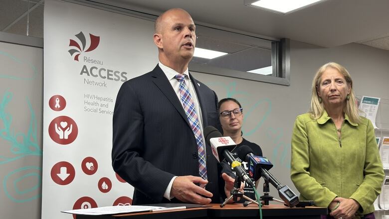 A bald man standing at a podium.