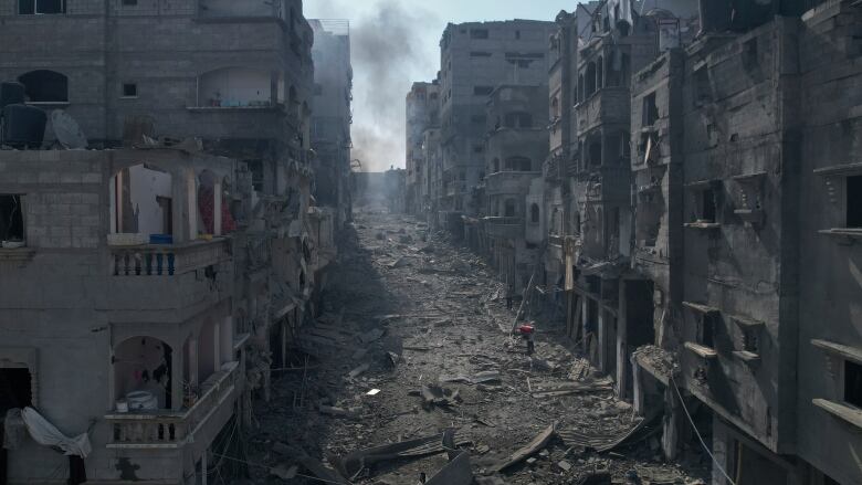 Rubble litters a street between smoldering buildings hit by an Israeli airstrike in Jabaliya, Gaza Strip, Wednesday, Oct. 11, 2023.