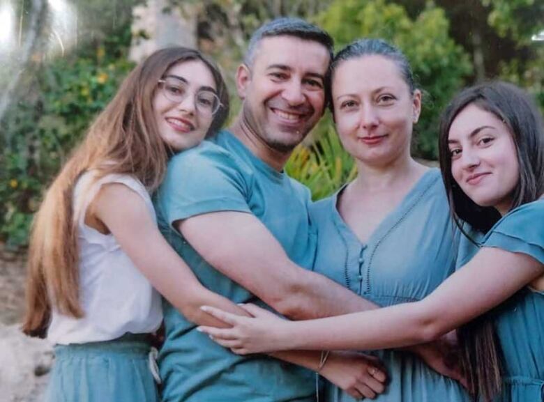 A family photo of Alexandra Arriev, far left, and her sister, Karina, far right with their parents.