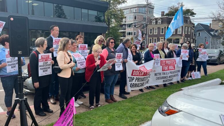 Members of the Canadian Health Coalition gather outside of a Charlottetown hotel holding signs asking for the end of privatized health care in Canada.