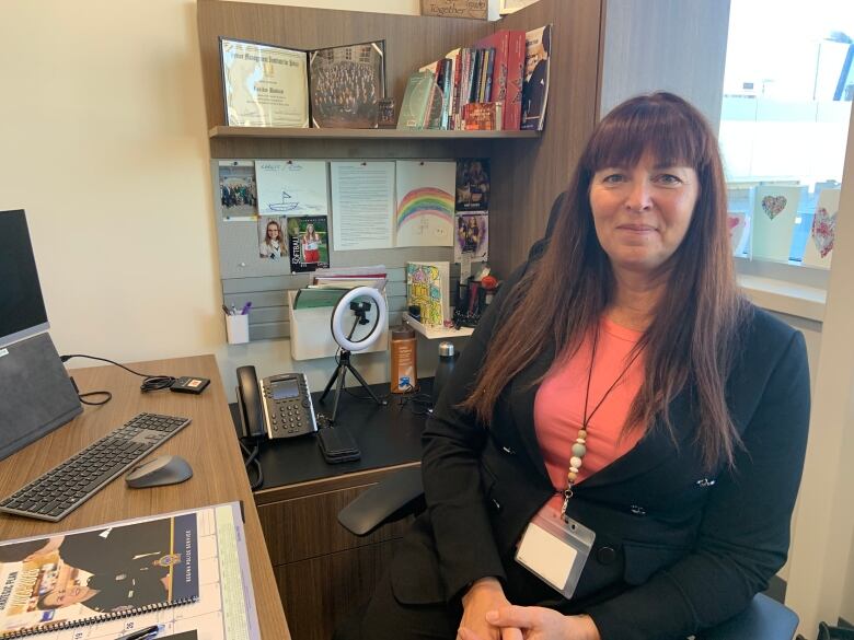 a woman in a suit sits in her office