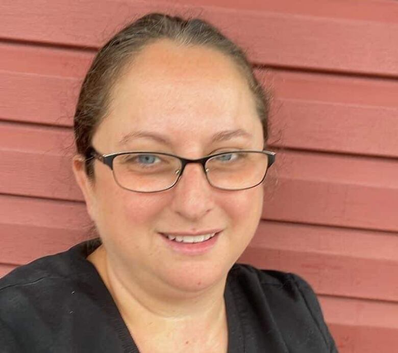 A smiling woman with rectangular glasses