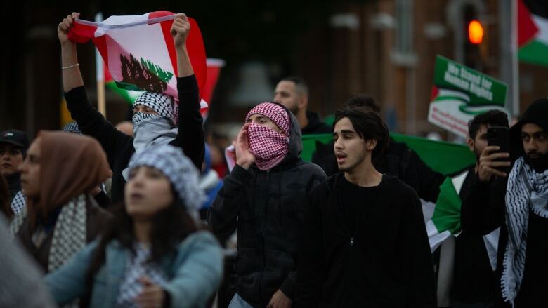 A group of people carrying Palestinian flags. 