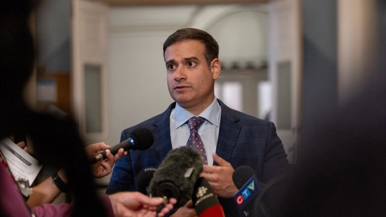 A man stands in front of microphones.