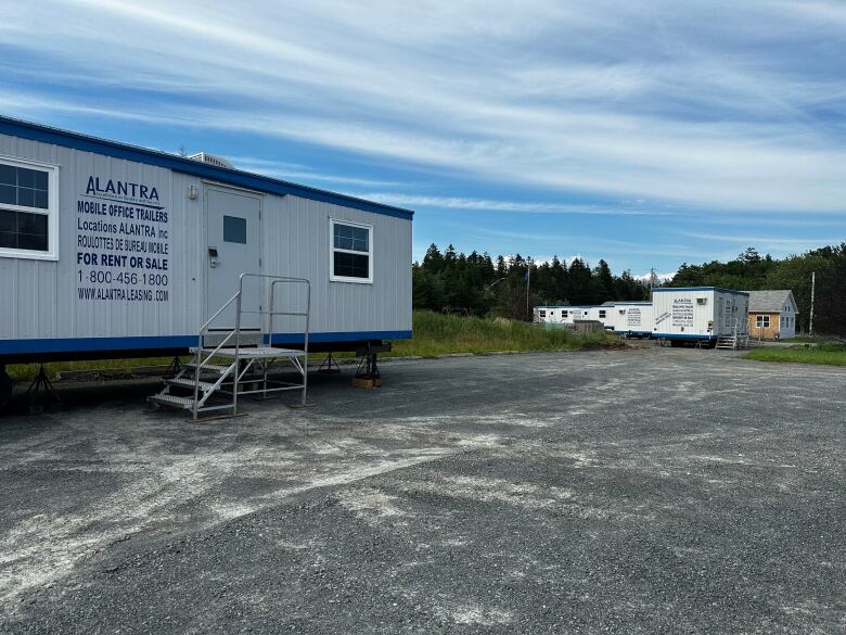 temporary trailers spread out in a gravel driveway. 