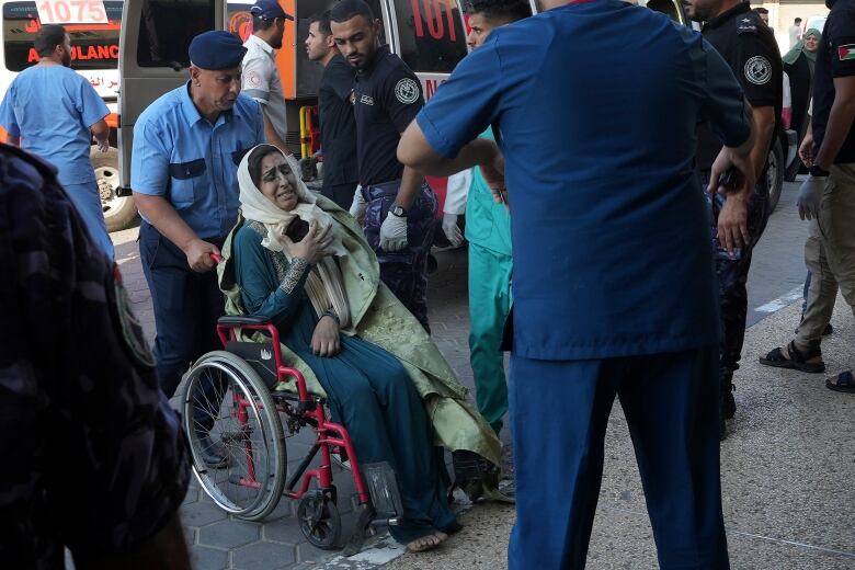 A man pushes a woman in a wheelchair.