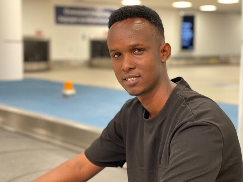 A man wearing a black T-shirt poses for the camera