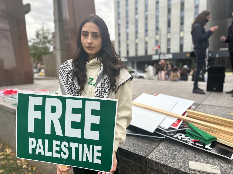 Woman holds sign that reads Free Palestine