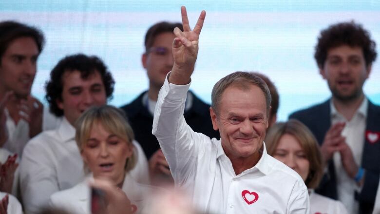 A person gestures the peace sign.