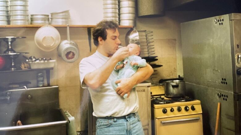 Dean DiCicco holds his son Logan in his arms inside the family restaurant Muldoon's on Wonderland Road. 