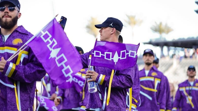 Men's lax team with flags.