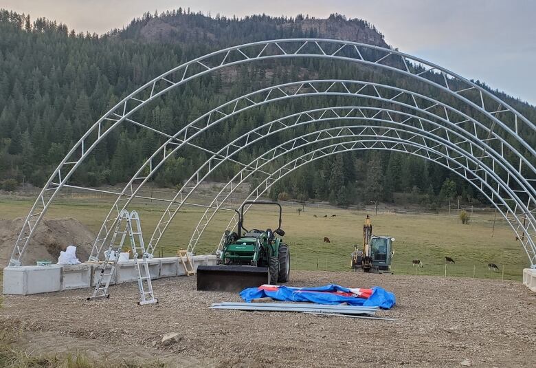 Arch support being set up with a dozer and a tractor in the background 