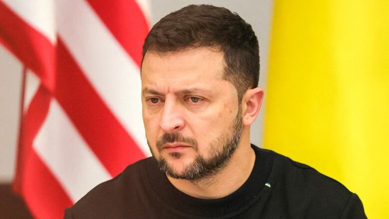 A person is seen clasping their hands as the listen at a news conference.