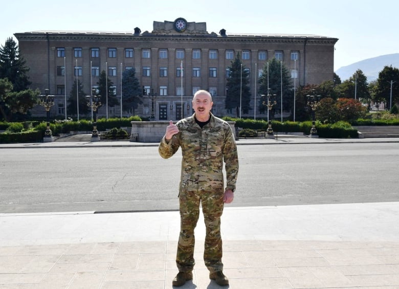  A man in uniform in front of building. 