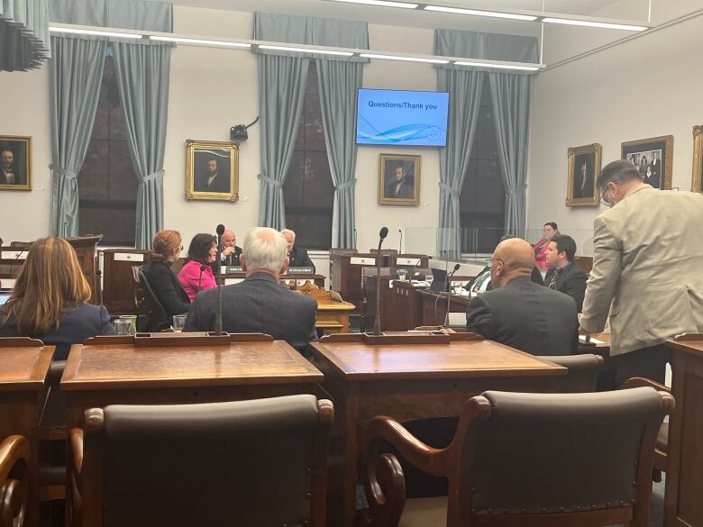 People sitting round table at committee meeting.