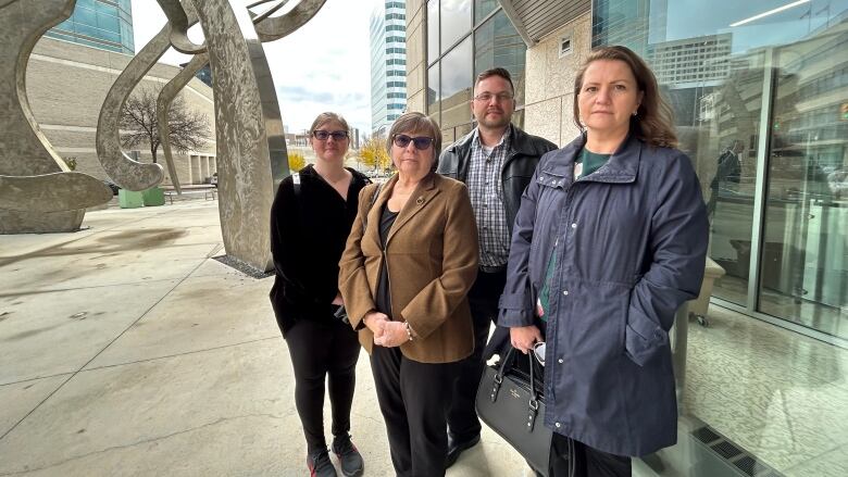 A family of four stand outside a law courts building.