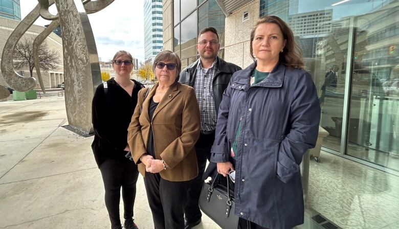 A family of four stand outside a law courts building.