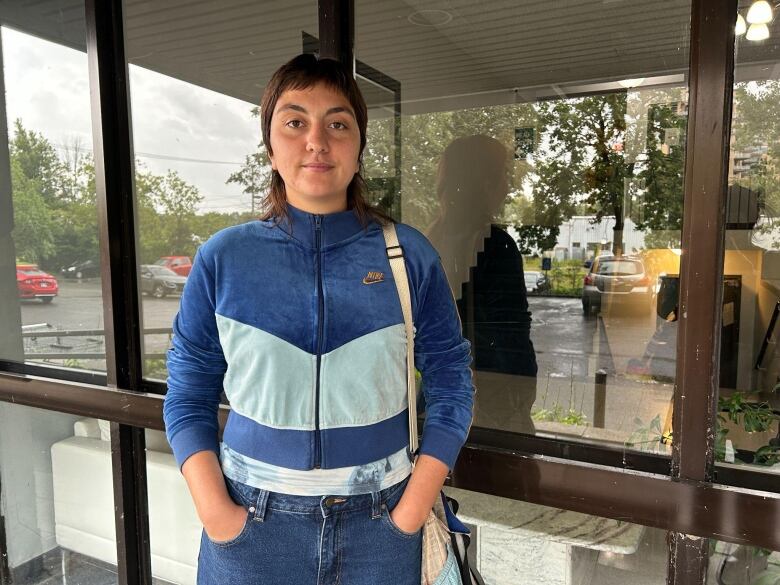 young woman in blue tracksuit outside apartment building