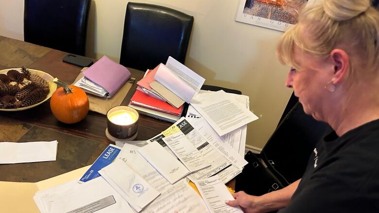 woman looking at table full of files