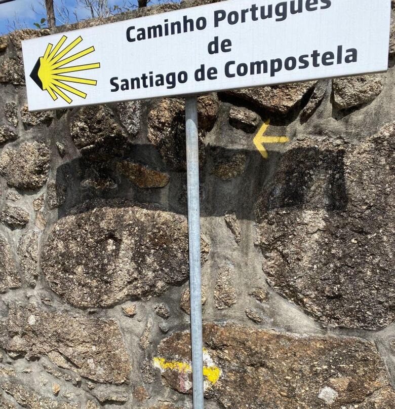 A stone wall with arrows pointing in opposite directions.