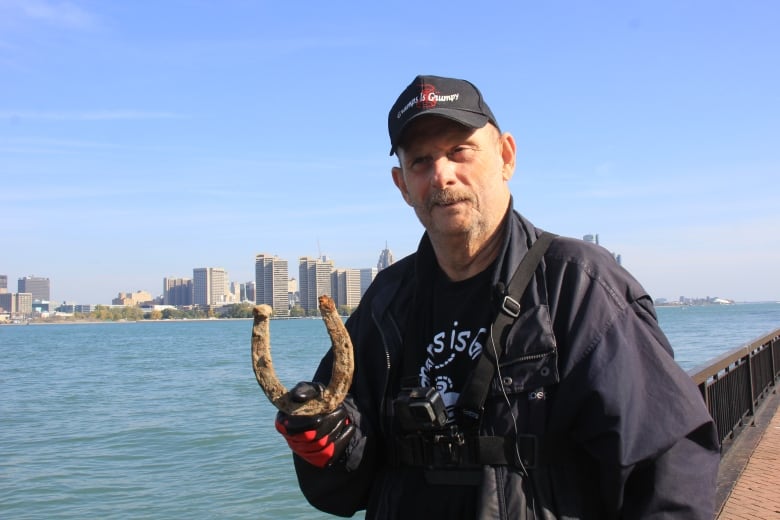 A man holds a horseshoe