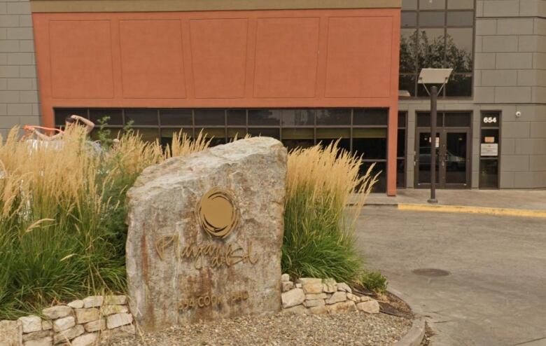 A rock with the words 'Playa del Sol' in front of a building.