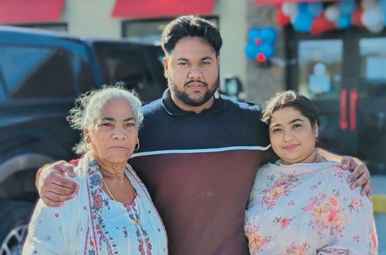 A man and two women stand in front of a Dairy Queen. 