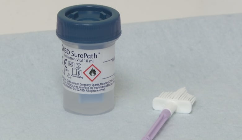 Vial of liquid labelled SurePath with a silicon swab lying next to it.