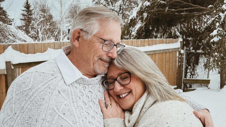 A couple embracing on a snowy day.