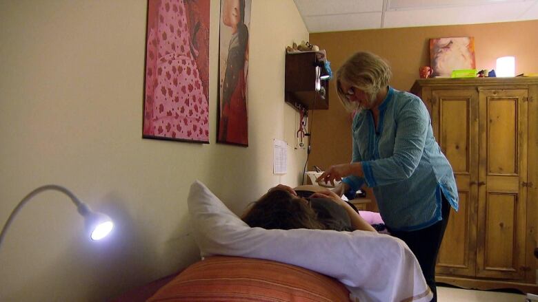 a midwife helping a pregnant woman in a health care setting