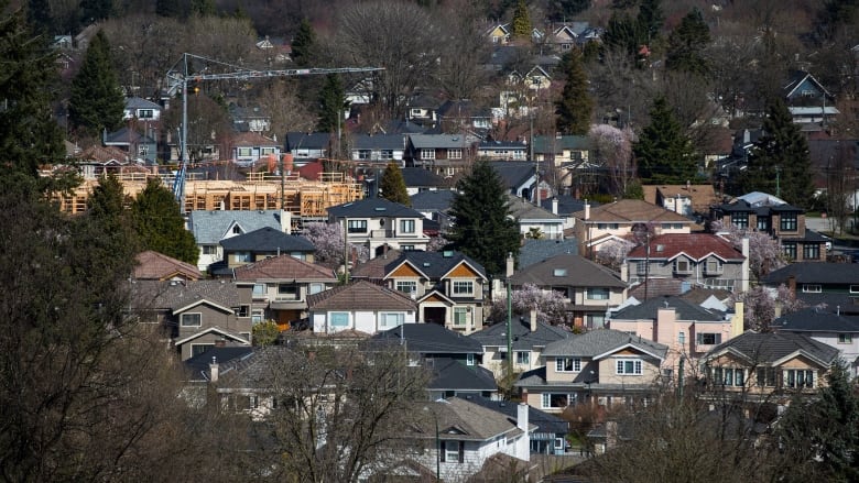 A condo building is seen under construction surrounded by houses in Vancouver, B.C.